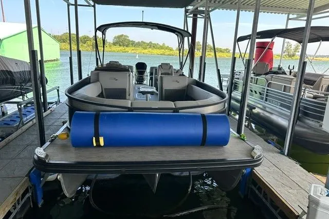Slide: The Image of 2021 Bennington L Bowrider 25 Quad Bench pontoon boat docked at marina. - 24