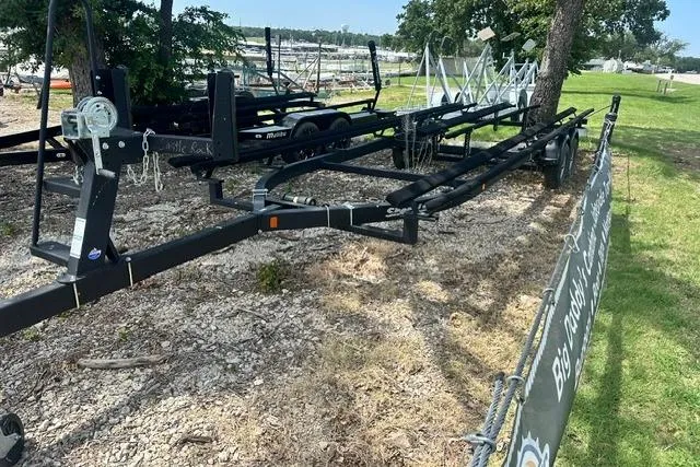 Slide: The Image of Boat trailers parked on gravel near a marina, surrounded by trees and grass. - 25