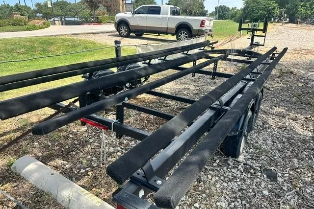 Slide: The Image of Trailer for 2021 Bennington L Bowrider 25 Quad Bench on gravel lot. - 27