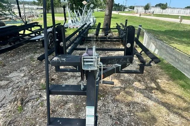 Slide: The Image of Boat trailer for 2021 Bennington L Bowrider 25 Quad Bench, parked outdoors on gravel. - 30