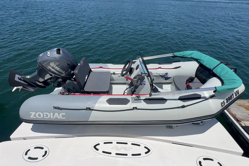 Slide: The Image of Inflatable Zodiac boat with Yamaha motor docked on water, near Sea Ray 58 Sedan Bridge. - 19