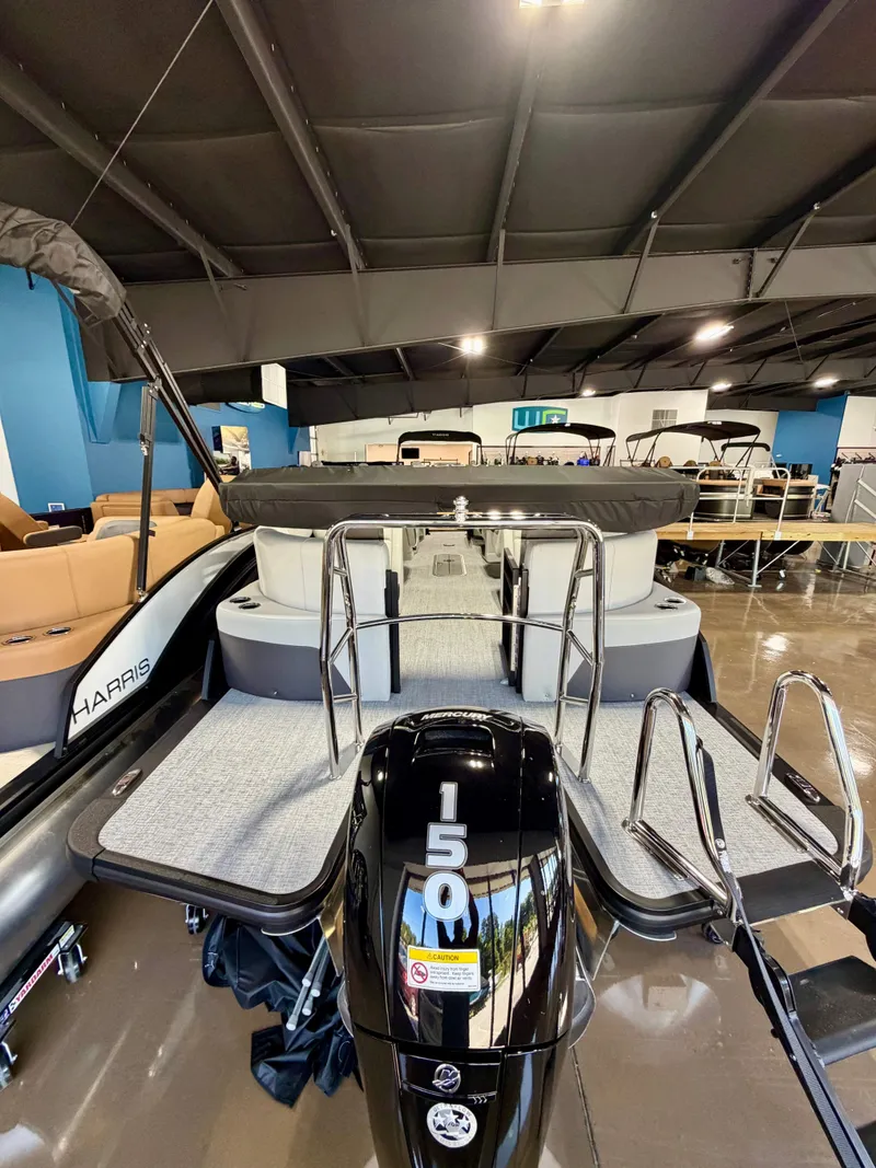 Slide: The Image of The image shows a Harris Cruiser 210 Heritage boat with a 150 HP outboard motor in a showroom. - 14
