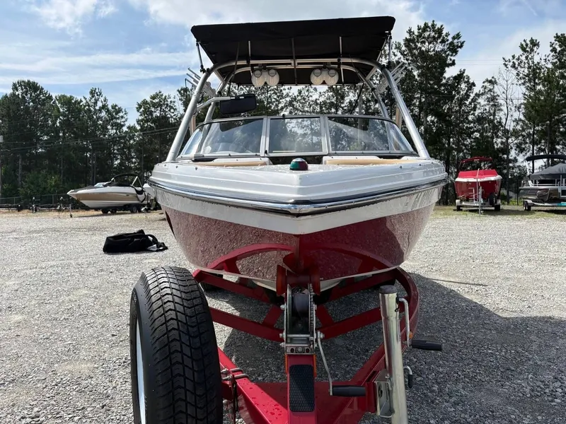 Slide: The Image of A 2006 Moomba Mobius LSV on a trailer, surrounded by trees and other boats. - 11