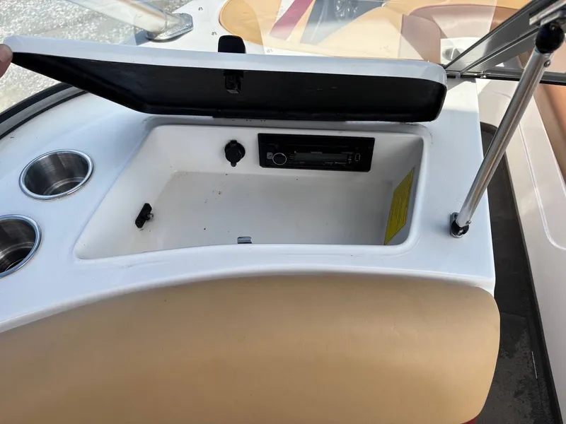 Slide: The Image of The image shows an open storage compartment on a boat with cup holders and a radio. - 13