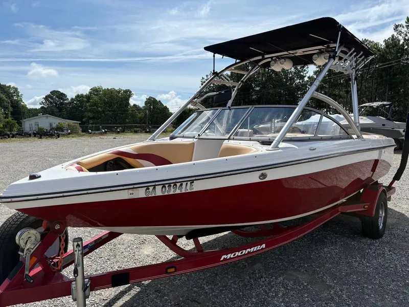 Slide: The Image of A red 2006 Moomba Mobius LSV boat on a trailer in a gravel lot. - 4
