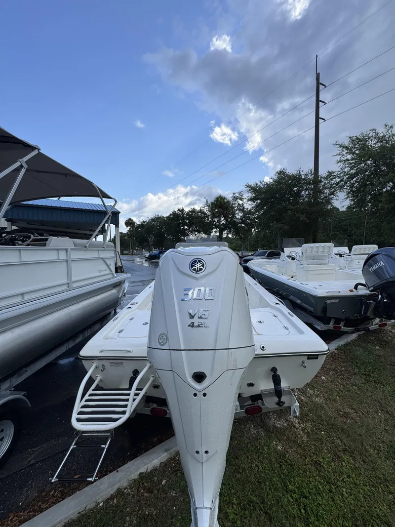Slide: The Image of A Skeeter SX Series SX241 boat with a 300 HP V6 engine, parked on a wet lot. - 10