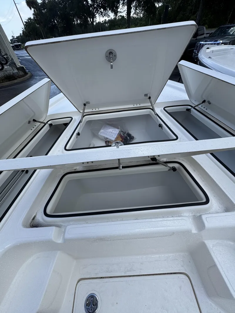 Slide: The Image of Open storage compartments on a boat with white lids and black seals. - 16