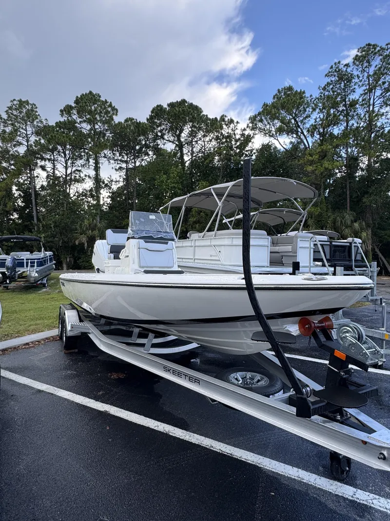 Slide: The Image of A white Skeeter SX Series SX241 boat on a trailer in a parking lot. - 2