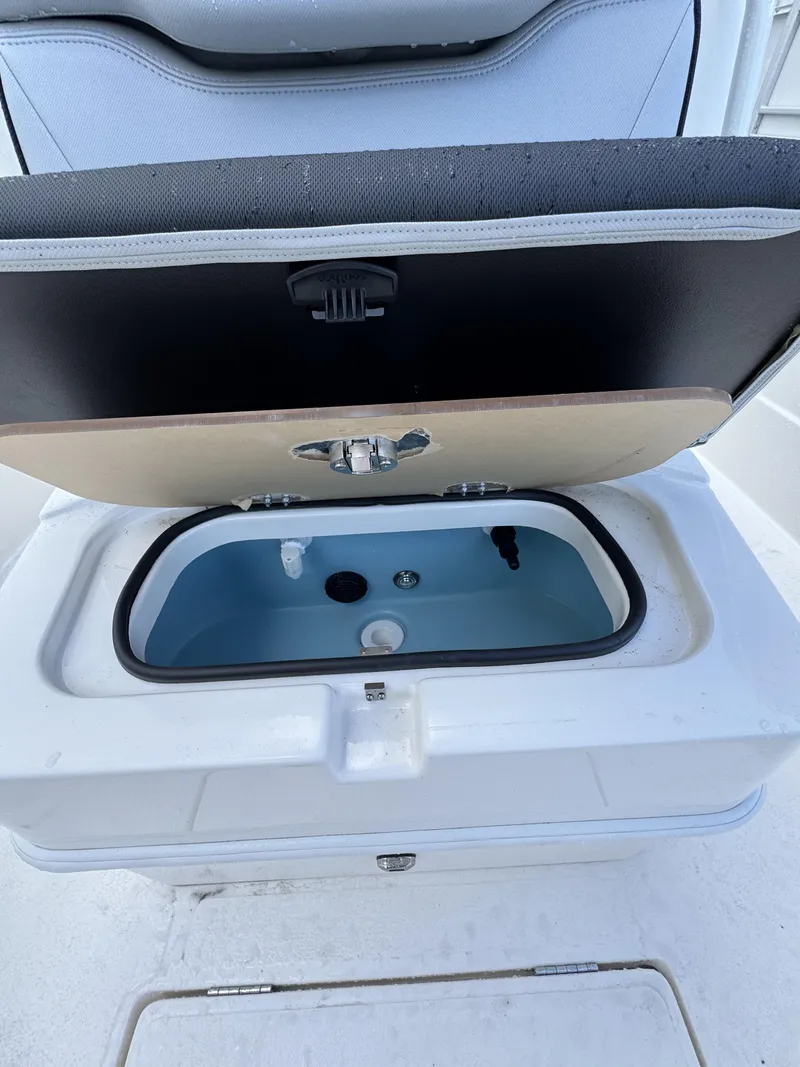 Slide: The Image of An open storage compartment on a boat with a blue interior and a black lid. - 20