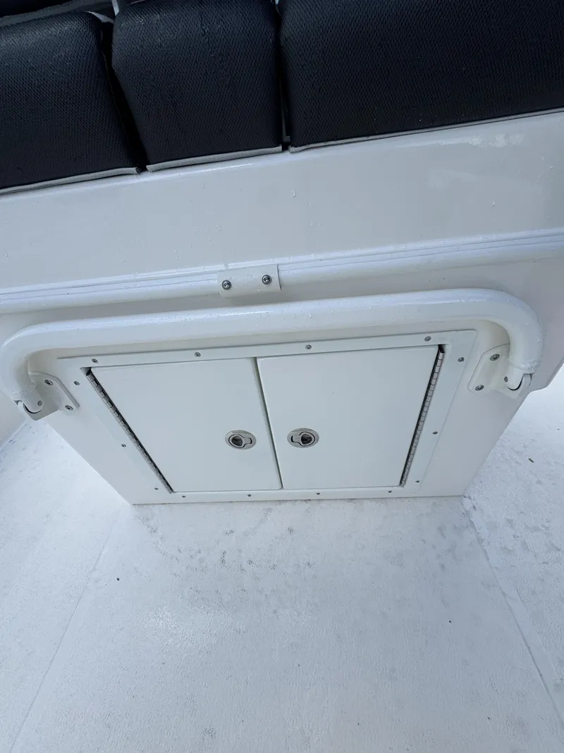Slide: The Image of White boat cabin with black seating and storage compartment below. - 33