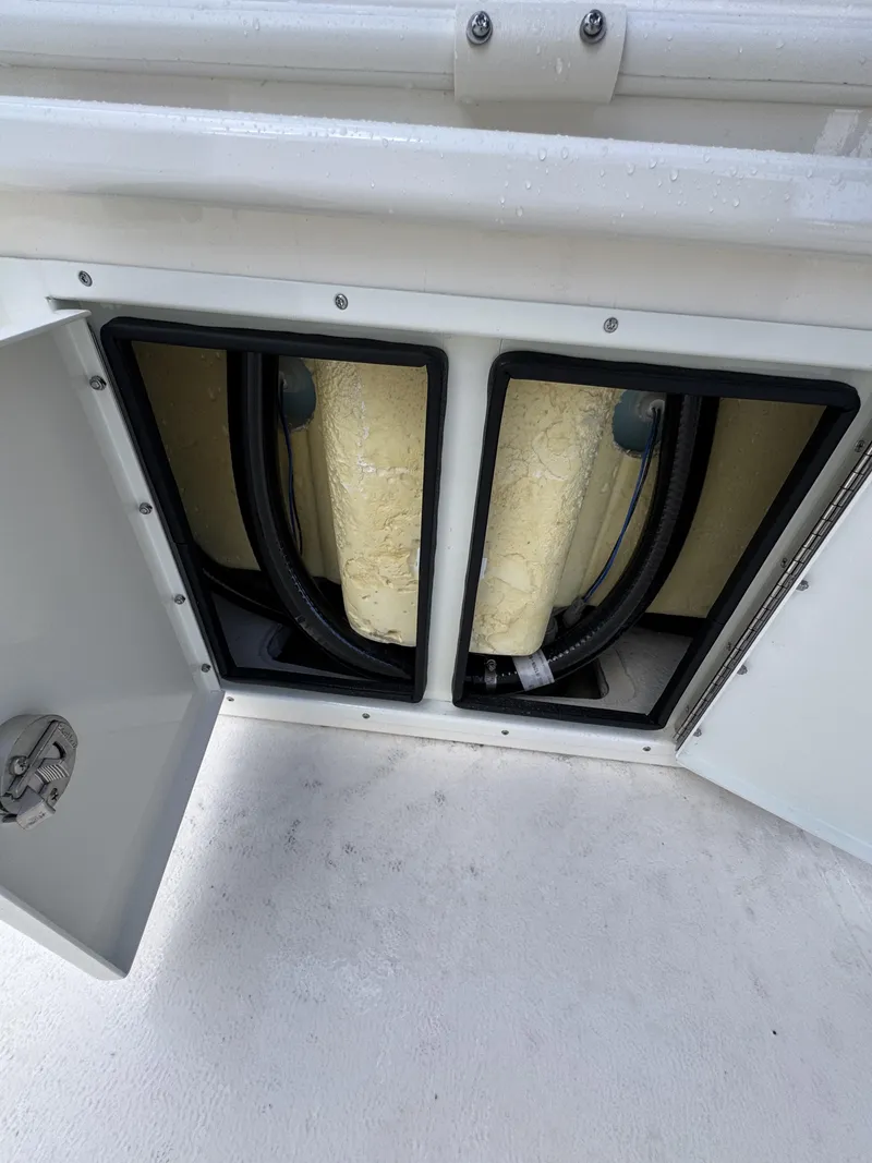 Slide: The Image of Open storage compartment with two yellow tanks and hoses. - 35