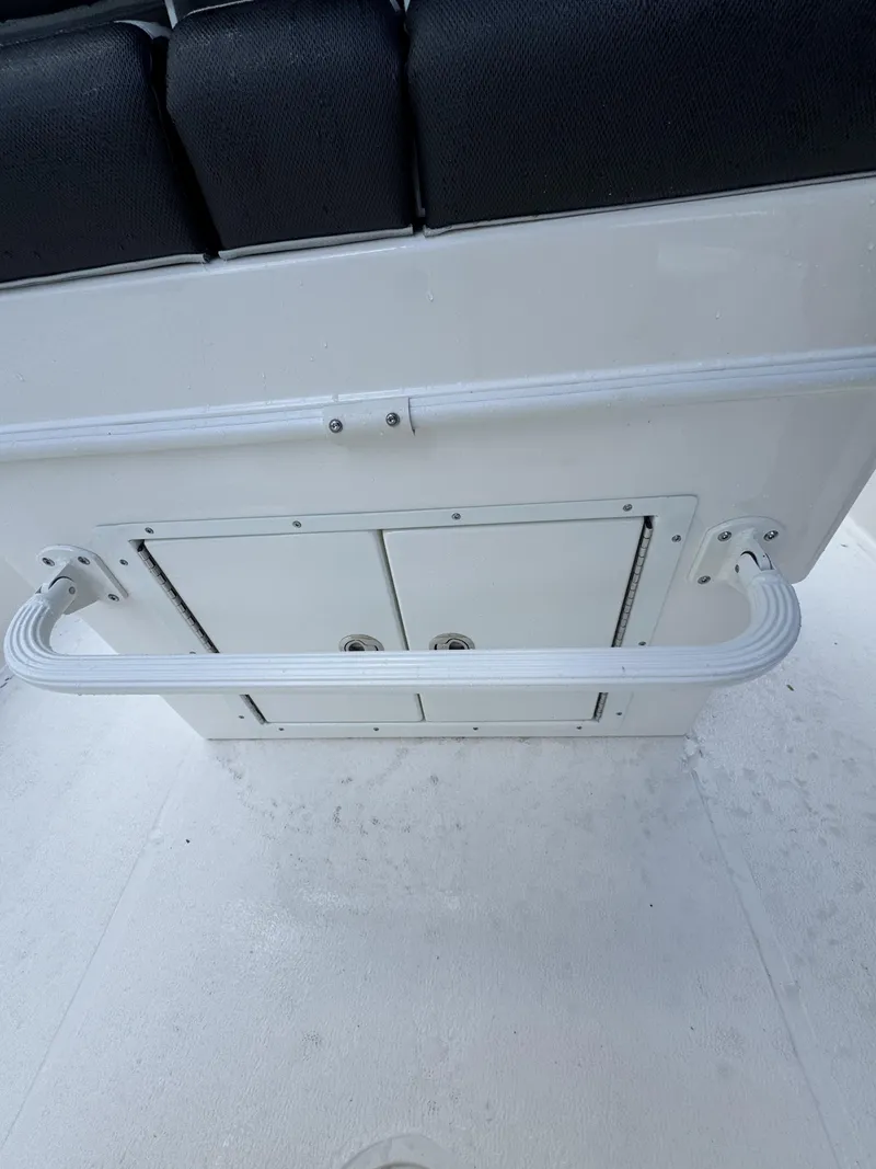 Slide: The Image of Rear view of a white boat seat with black upholstery and a grab rail. - 36