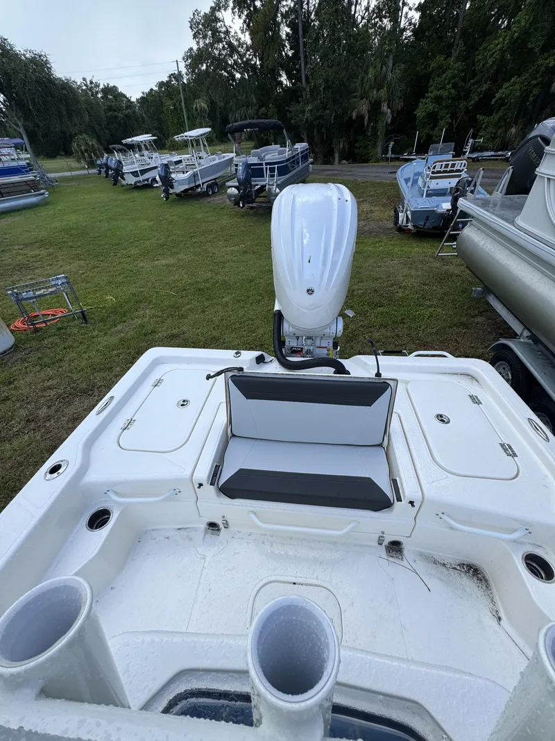 Slide: The Image of The image shows the stern of a white boat with an outboard motor and seating area. - 37