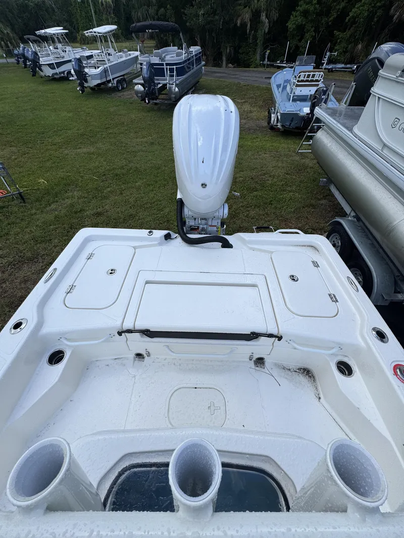 Slide: The Image of The image shows the stern of a white boat with an outboard motor. It is on grass. - 38