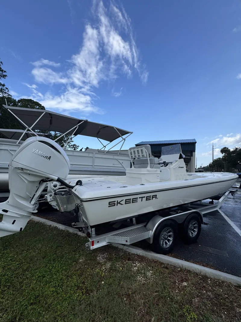 Slide: The Image of A white Skeeter SX Series SX241 boat on a trailer, parked in a lot. - 4