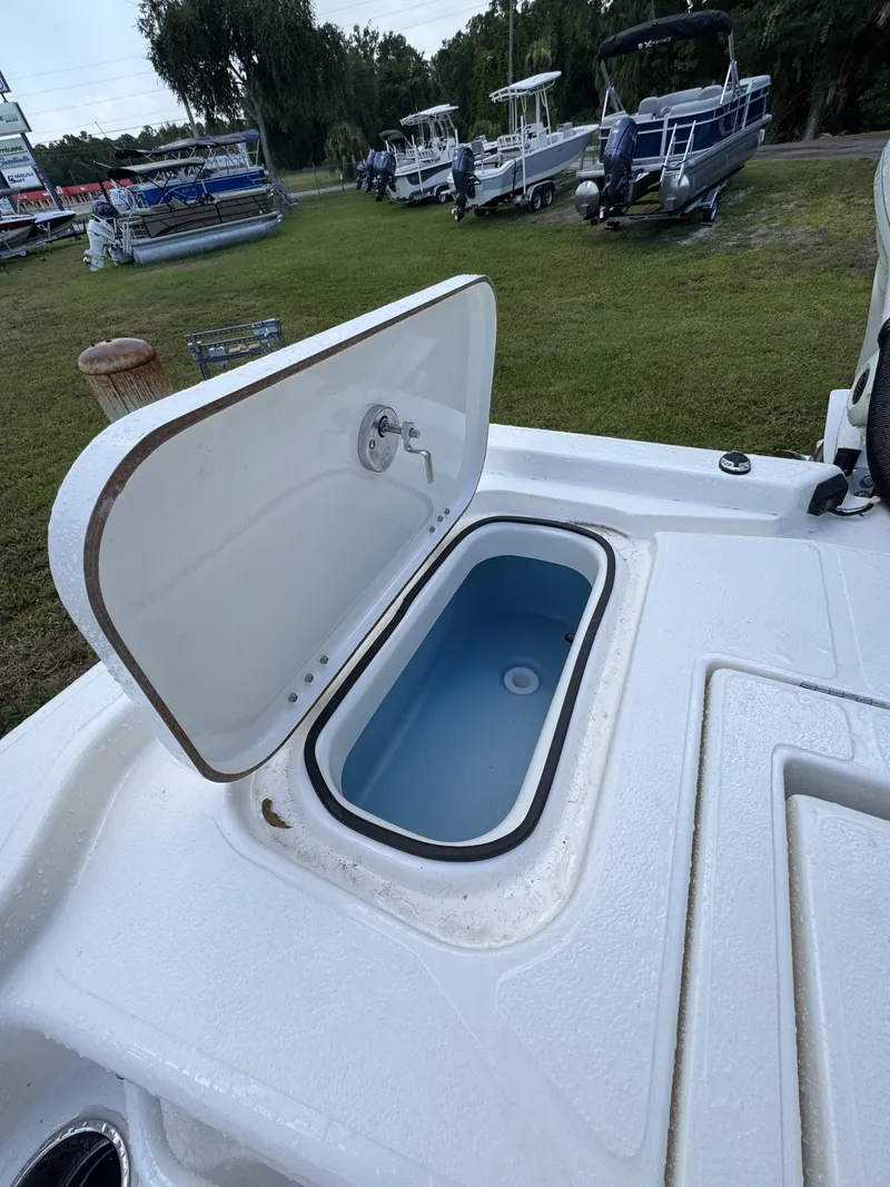 Slide: The Image of An open storage compartment on a boat with a blue interior, surrounded by other boats on grass. - 44