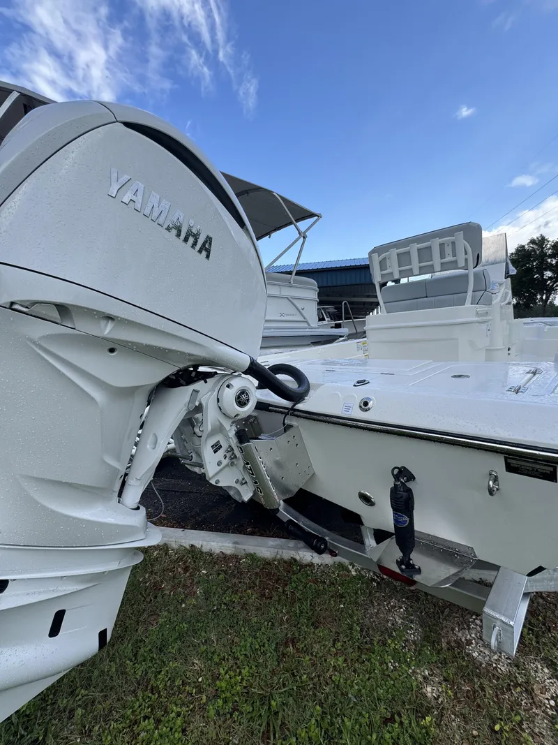 Slide: The Image of A white boat with a Yamaha outboard motor is on a trailer on grass. - 6