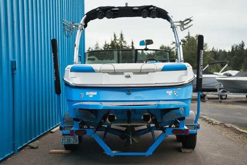 Slide: The Image of Rear view of a blue 2016 MasterCraft NXT20 boat parked beside a blue building. - 3
