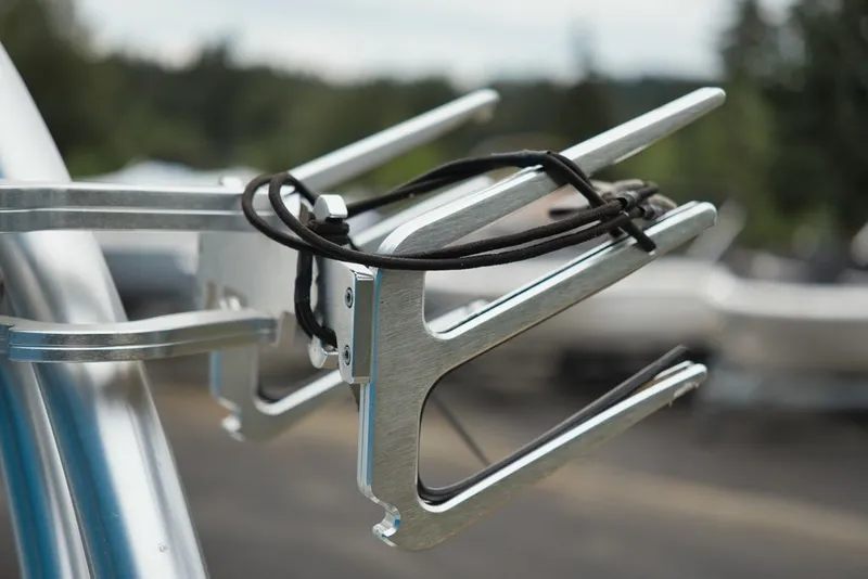 Slide: The Image of Close-up of a silver wakeboard rack on a boat, with trees in the background. - 14