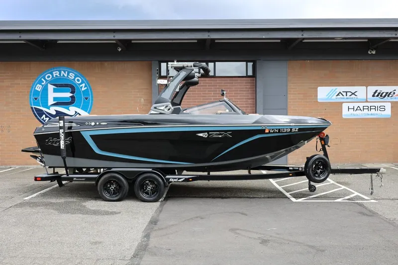The Image of 2021 Tigé 23ZX boat on trailer, parked outside Bjornson Marine dealership. - 1