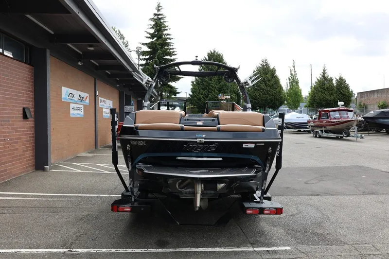 Slide: The Image of 2021 Tigé 23ZX boat parked outside dealership, showcasing rear view and sleek design. - 11
