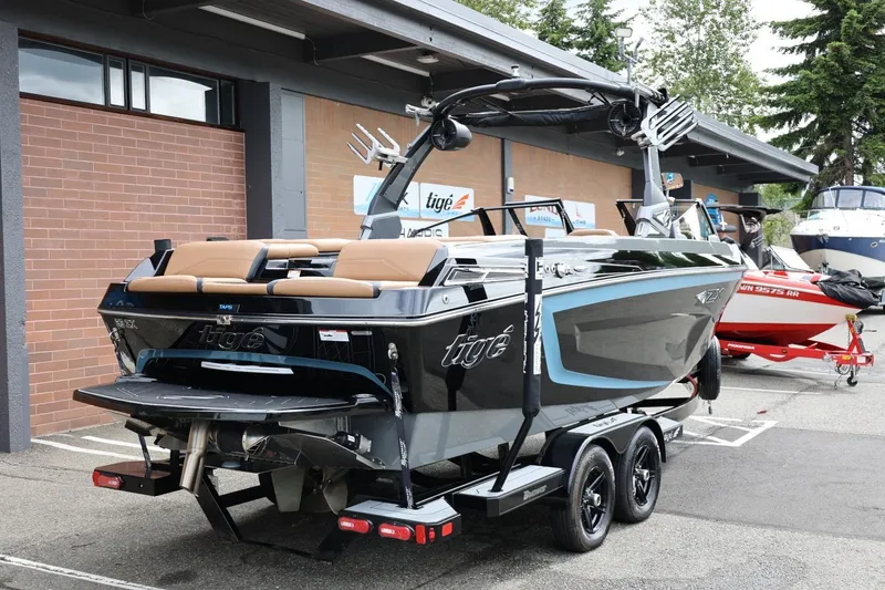 Slide: The Image of 2021 Tigé 23ZX boat on trailer, parked outside dealership, showcasing sleek design and modern features. - 13