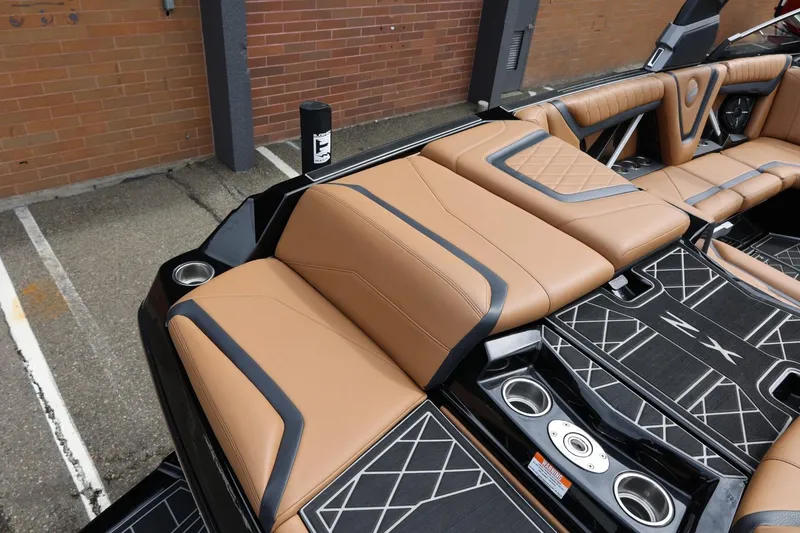 Slide: The Image of 2021 Tigé 23ZX boat interior with tan leather seats and sleek black accents. - 15