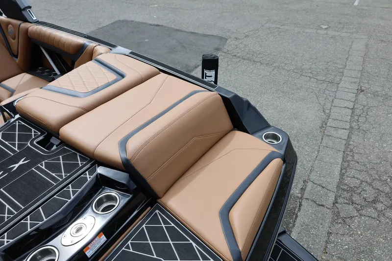 Slide: The Image of 2021 Tigé 23ZX boat interior with tan leather seats and cup holders. - 16