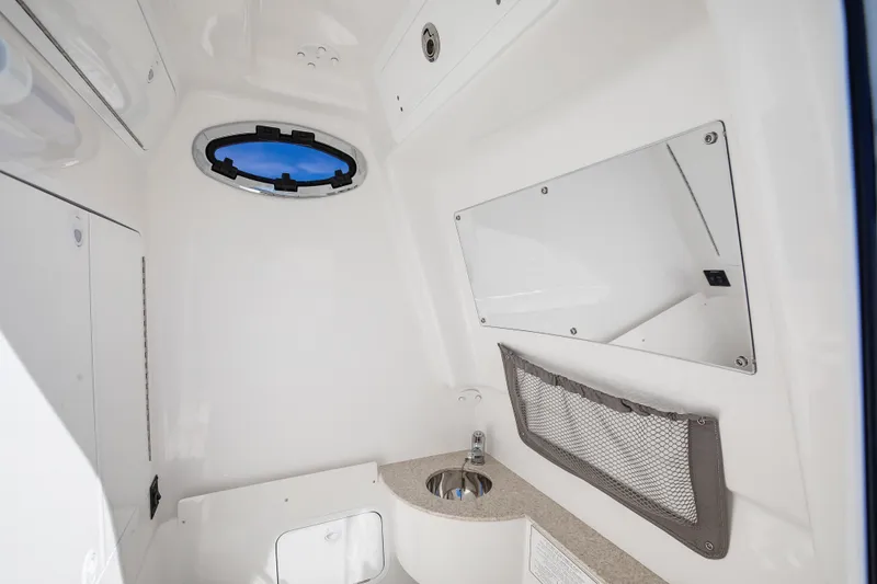 Slide: The Image of 2022 Regulator 28 Forward Seating interior with porthole, sink, and storage net. - 12