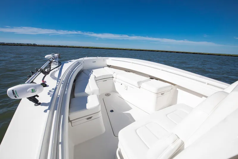 Slide: The Image of 2022 Regulator 28 Forward Seating boat on calm water under clear blue sky. - 10