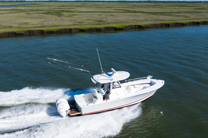 Slide: The Image of 2022 Regulator 28 Forward Seating boat cruising on a scenic waterway. - 20