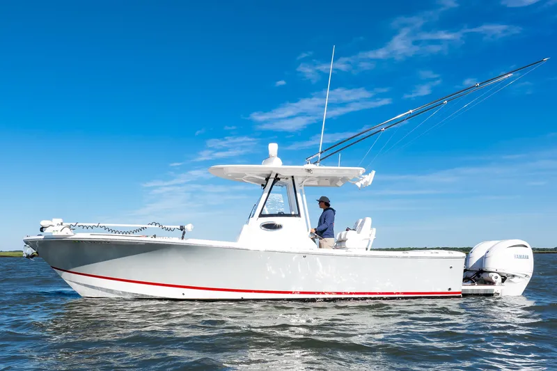 Slide: The Image of 2022 Regulator 28 Forward Seating boat on water, clear blue sky background. - 2