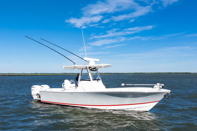 Slide: The Image of 2022 Regulator 28 Forward Seating boat cruising on open water under clear blue sky. - 23