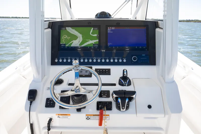 Slide: The Image of 2022 Regulator 28 Forward Seating boat dashboard with dual navigation screens and steering wheel. - 7
