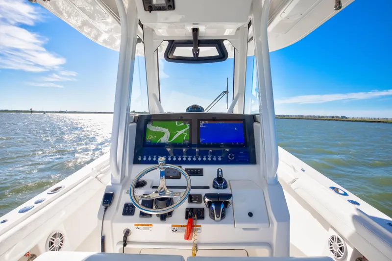 Slide: The Image of 2022 Regulator 28 Forward Seating boat dashboard with navigation screens on open water. - 6