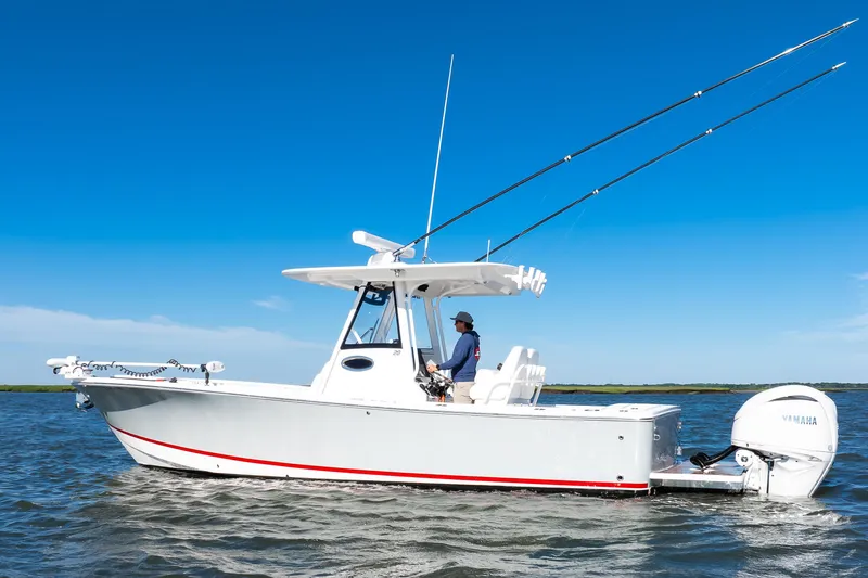 Slide: The Image of 2022 Regulator 28 Forward Seating boat on water, clear blue sky background. - 4
