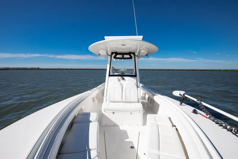 Slide: The Image of 2022 Regulator 28 Forward Seating boat on open water under clear blue sky. - 11