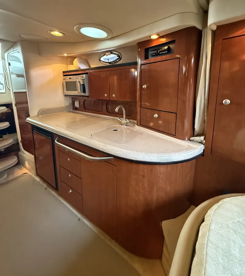 Slide: The Image of The interior of a 2007 Sea Ray 340 Sundancer features an elegant galley with wooden cabinetry. - 25