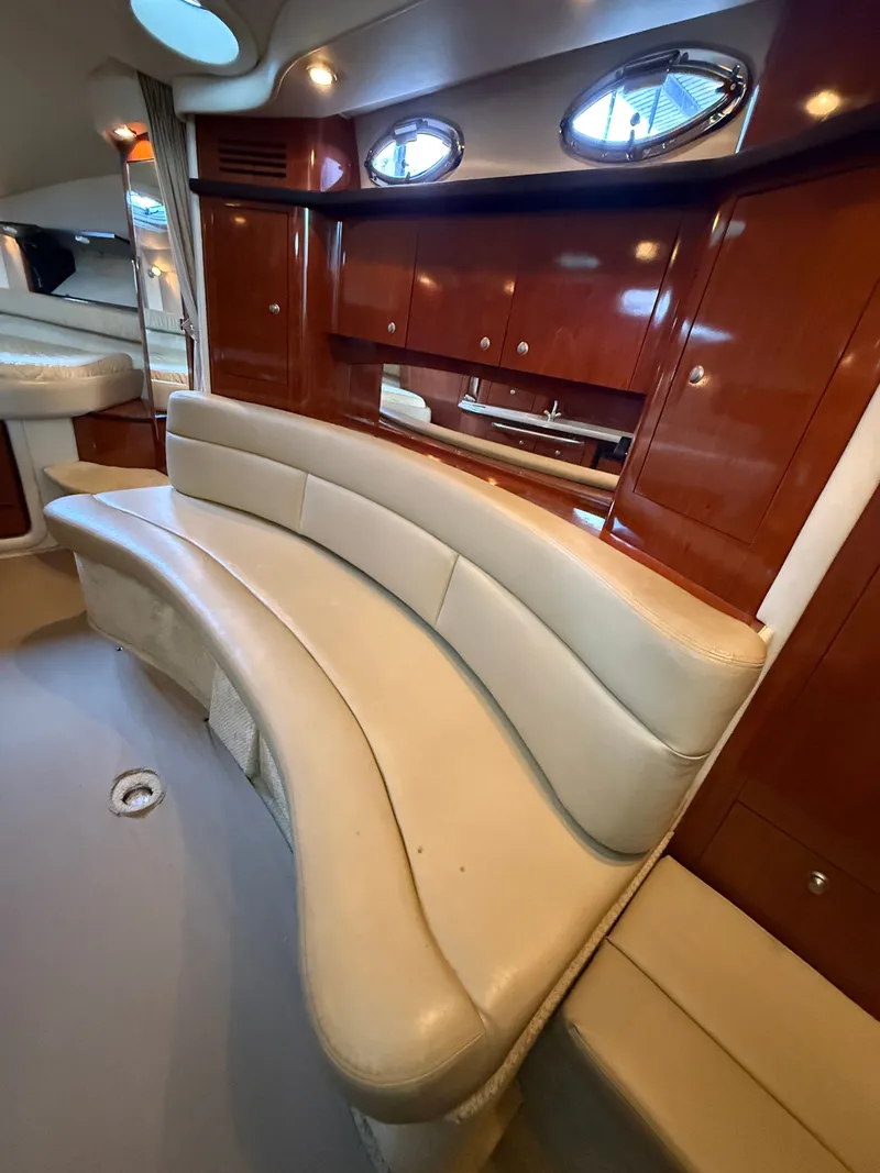 Slide: The Image of Interior of a 2007 Sea Ray 340 Sundancer with a curved leather sofa and wooden cabinetry. - 28