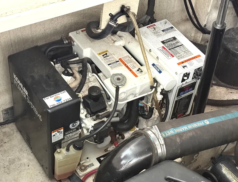 Slide: The Image of An engine compartment with a generator and various hoses and cables. - 34