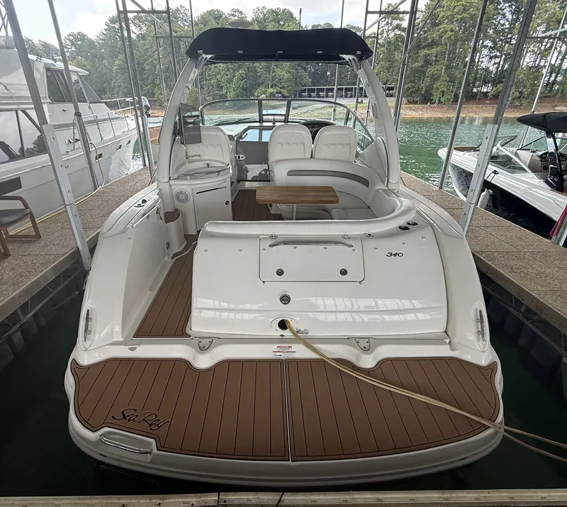 Slide: The Image of A 2007 Sea Ray 340 Sundancer is docked under a covered area, featuring a spacious aft deck. - 12
