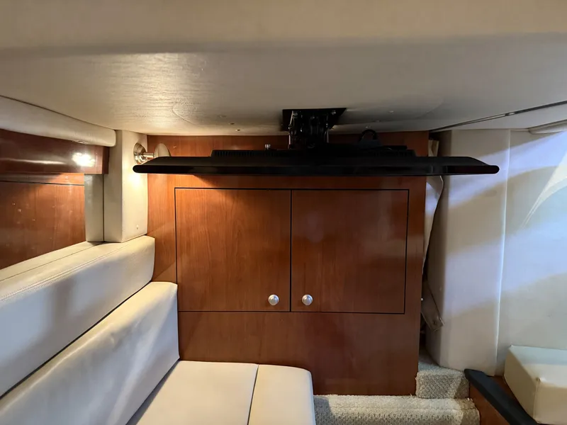 Slide: The Image of The cabin of a 2007 Sea Ray 340 Sundancer with wood cabinetry and a television. - 30
