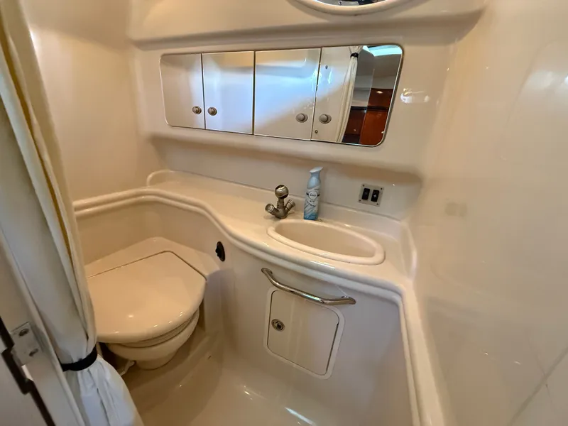 Slide: The Image of The image shows a clean boat bathroom with a sink, toilet, and mirror. - 32