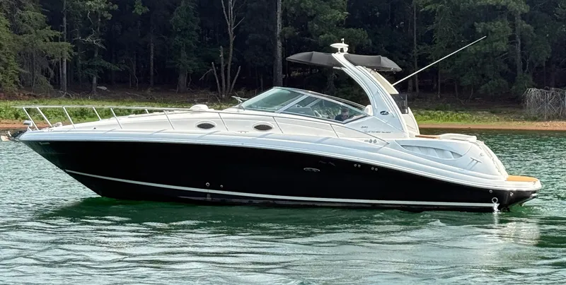 The Image of A black 2007 Sea Ray 340 Sundancer on calm water near a wooded shoreline. - 1