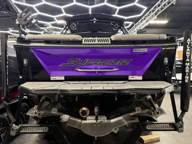 Slide: The Image of The image shows the rear of a 2020 Supreme ZS 232 boat in a showroom. - 26