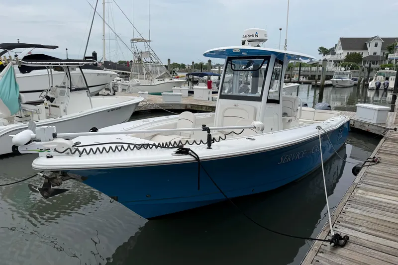 The Image of 2020 Sea Hunt Ultra 275 SE boat docked at marina, featuring blue hull and Garmin equipment. - 1