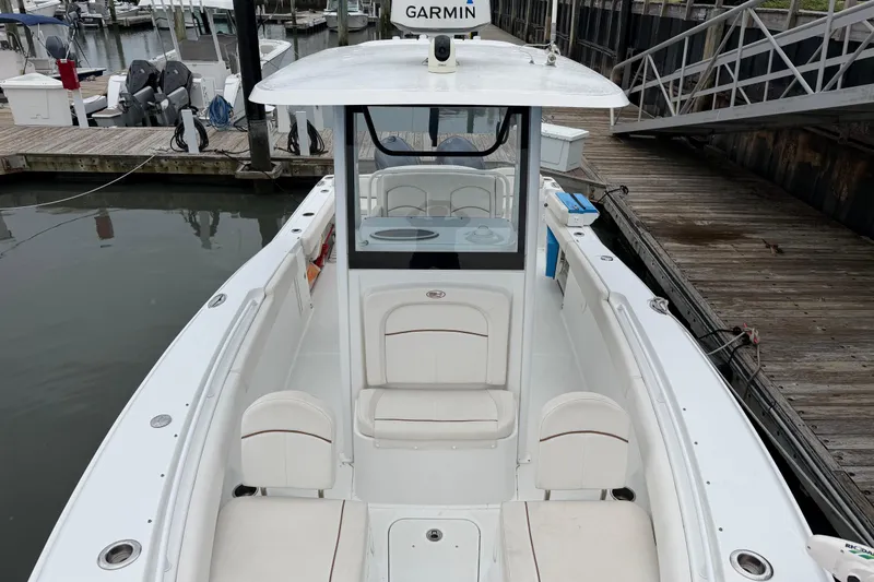 Slide: The Image of 2020 Sea Hunt Ultra 275 SE boat docked, featuring spacious seating and Garmin navigation system. - 14