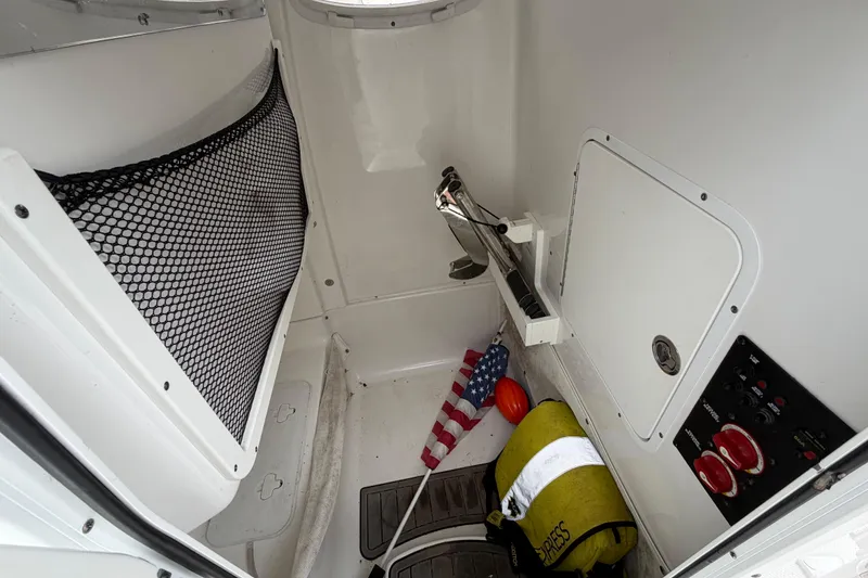 Slide: The Image of Interior storage compartment of 2020 Sea Hunt Ultra 275 SE boat with safety equipment. - 15
