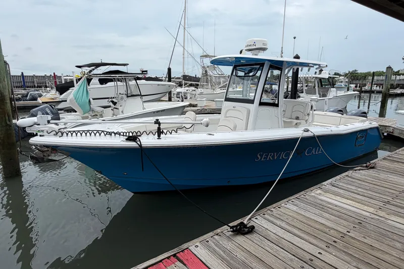 Slide: The Image of 2020 Sea Hunt Ultra 275 SE boat docked at marina, blue hull, calm water. - 2