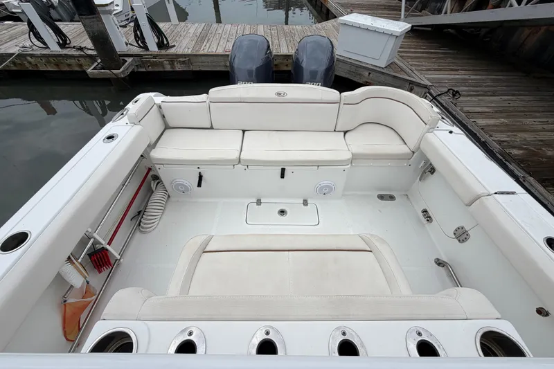 Slide: The Image of 2020 Sea Hunt Ultra 275 SE boat interior with white seating and docked at marina. - 8